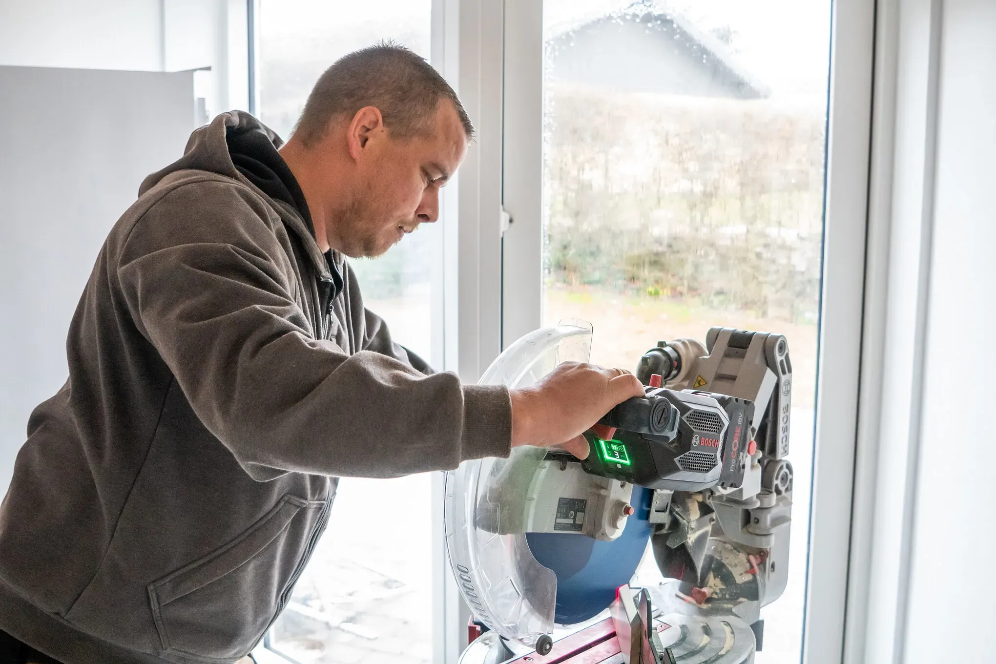 Tømrer udfører tømrerarbejde med måling og tilpasning af materialer indendørs i Vestsjælland