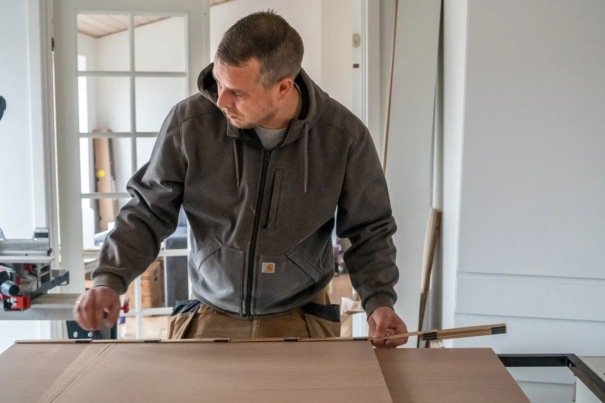Tømrer udfører tømrerarbejde med opmåling og tilpasning af materialer ved renovering i Vestsjælland